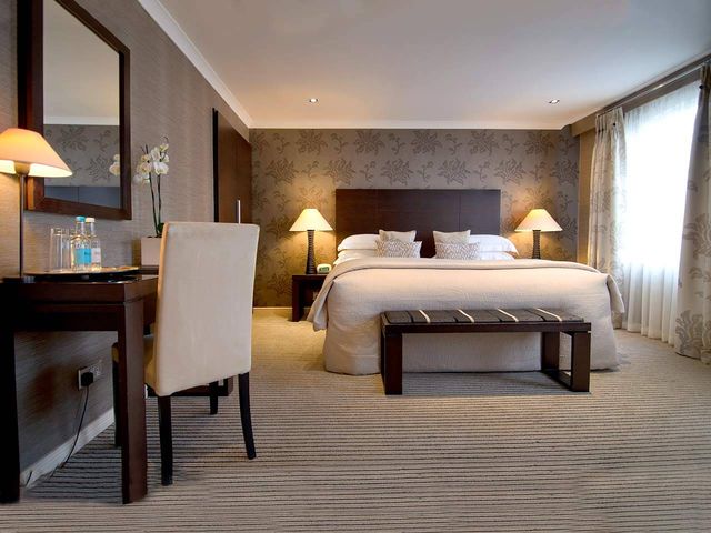 Deluxe Room with large bed and side table in the Beaufort Hotel