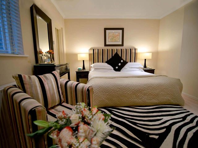 Luxury Deluxe Room with Bed, armchair and zebra print rug in the Beaufort Hotel