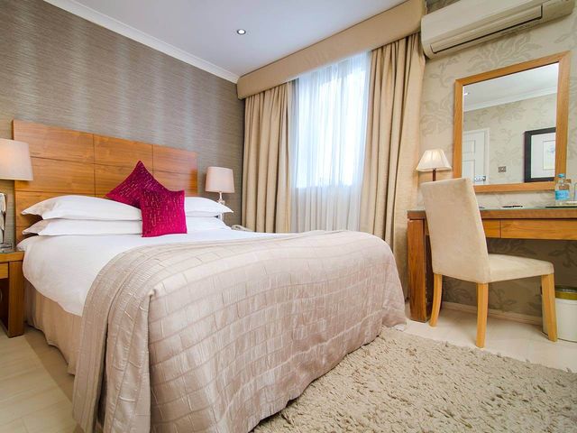 large deluxe double room in the Beaufort Hotel with side table and mirror