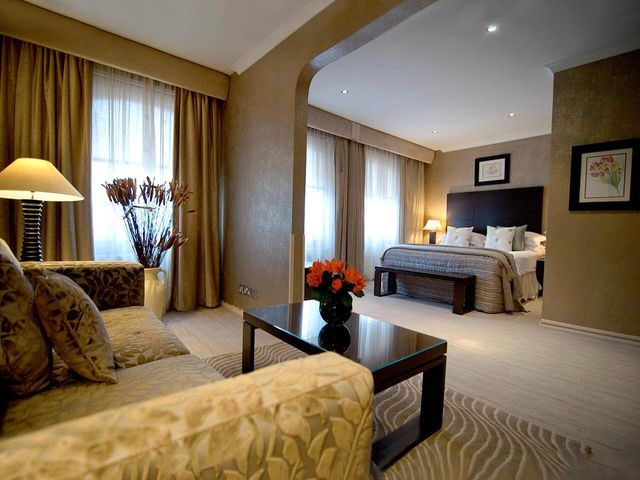 Junior Suite with large king size bed and sofa in the Beaufort Hotel